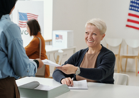 WOMAN ACCEPTING BALLOT AT POLL