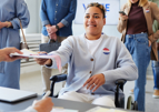 WOMAN HANDING IN BALLOT FROM WHEELCHAIR